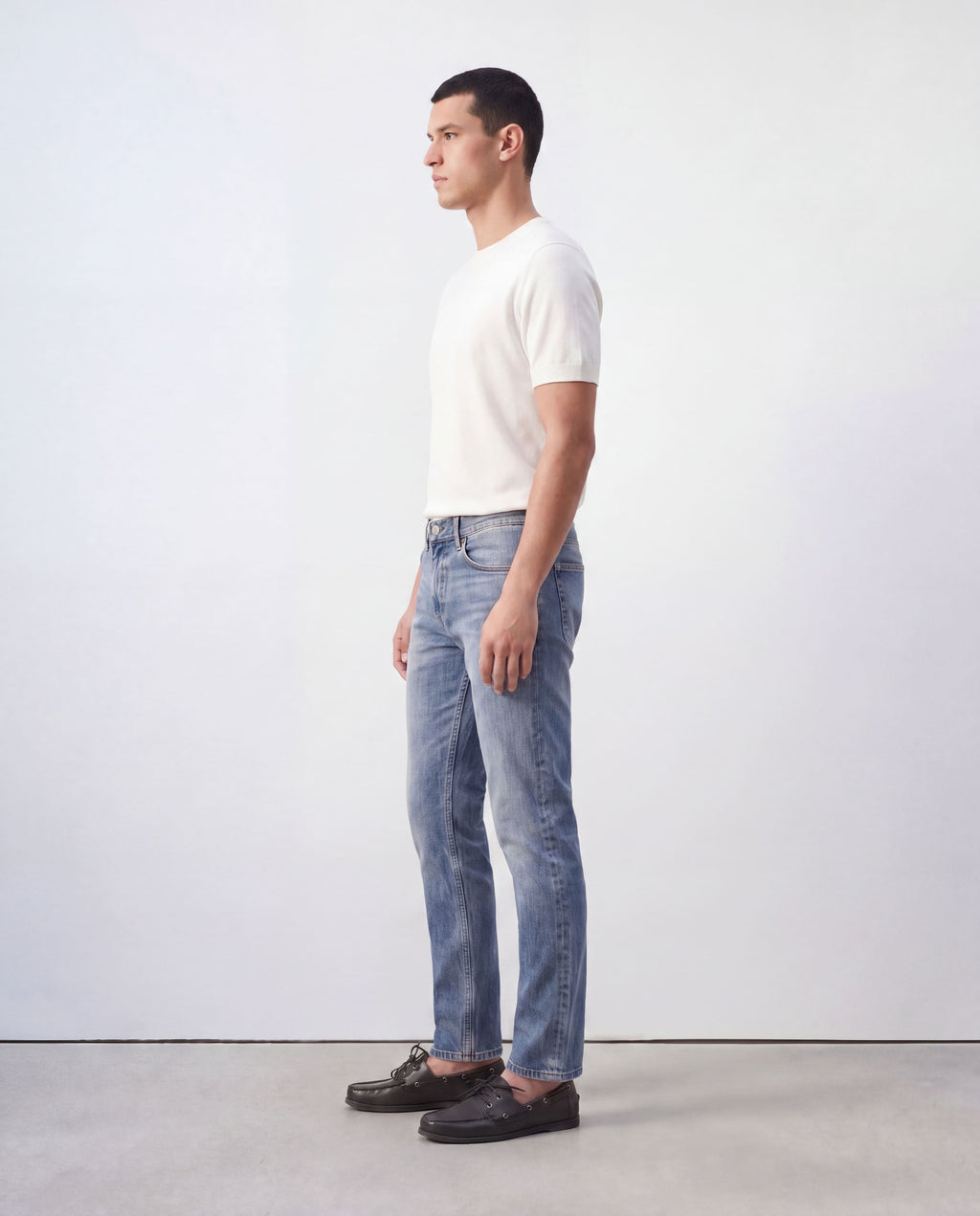 Side profile view of model wearing Sama Denim men's light wash slim fit jeans