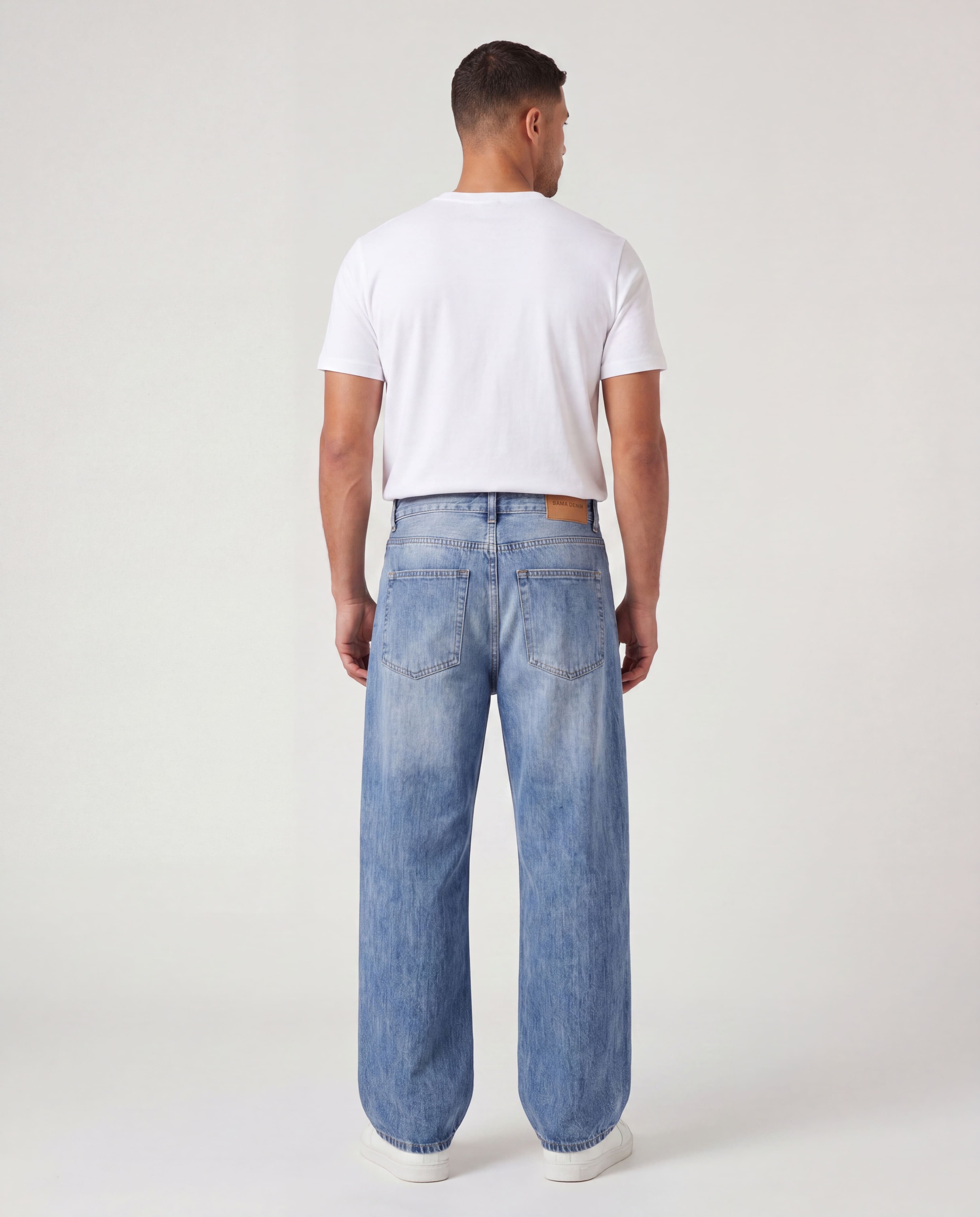 Back view of model wearing Sama Denim men's light wash baggy fit jeans