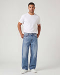 Model wearing Sama Denim men's light wash baggy fit jeans with relaxed styling