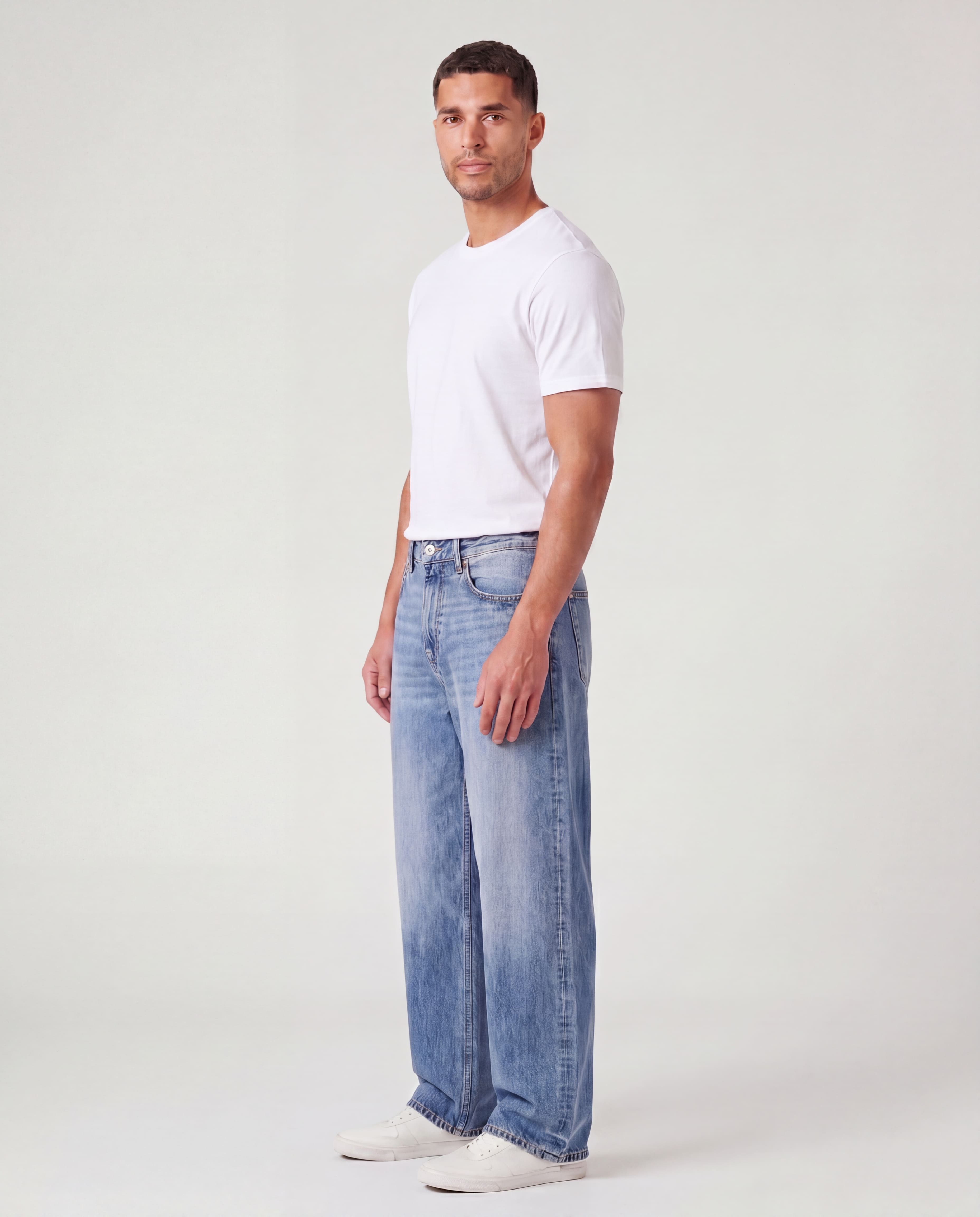 Side view of model wearing Sama Denim men's light wash baggy fit jeans