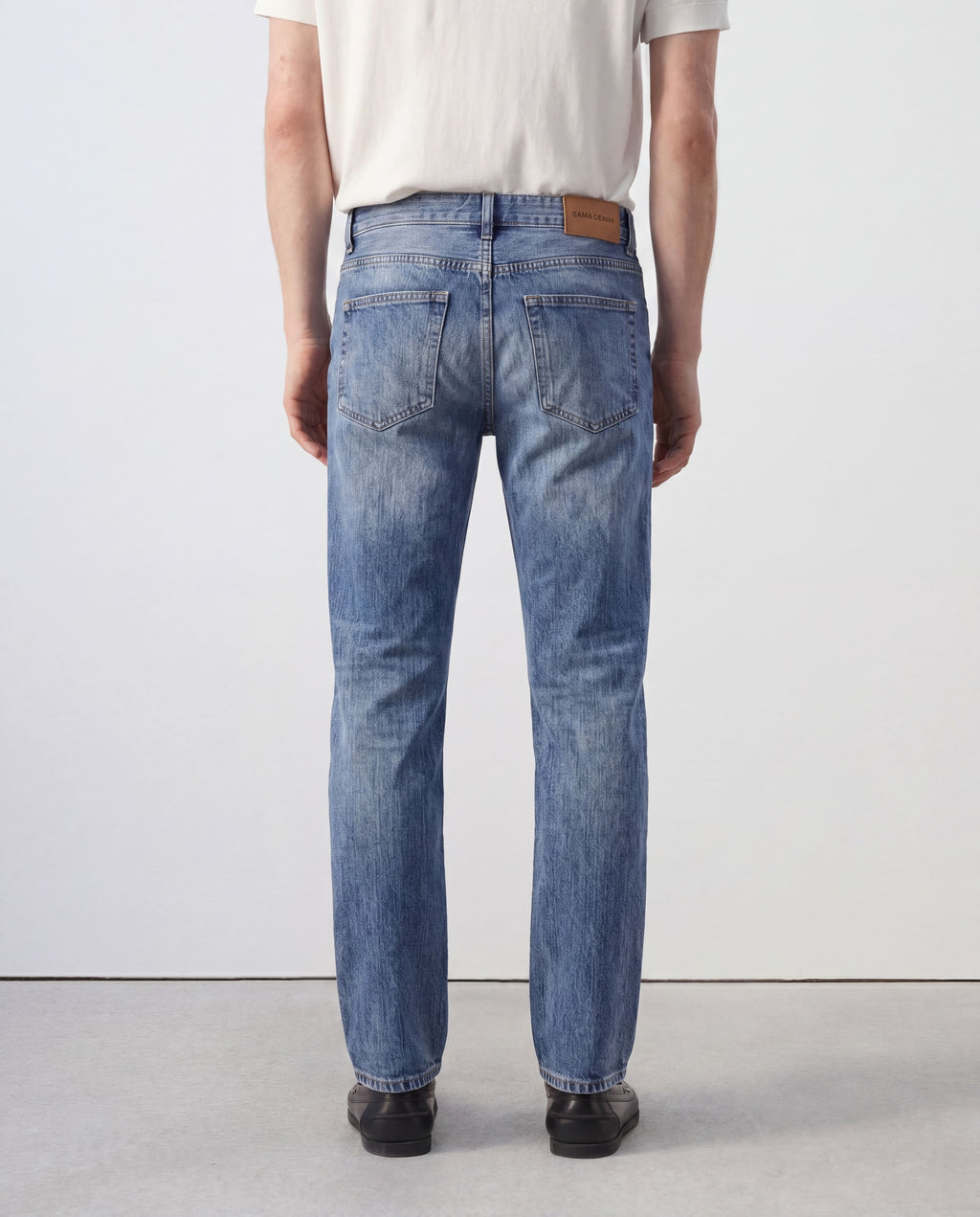 Back view of Sama Denim men's light wash slim fit jeans with minimalist styling