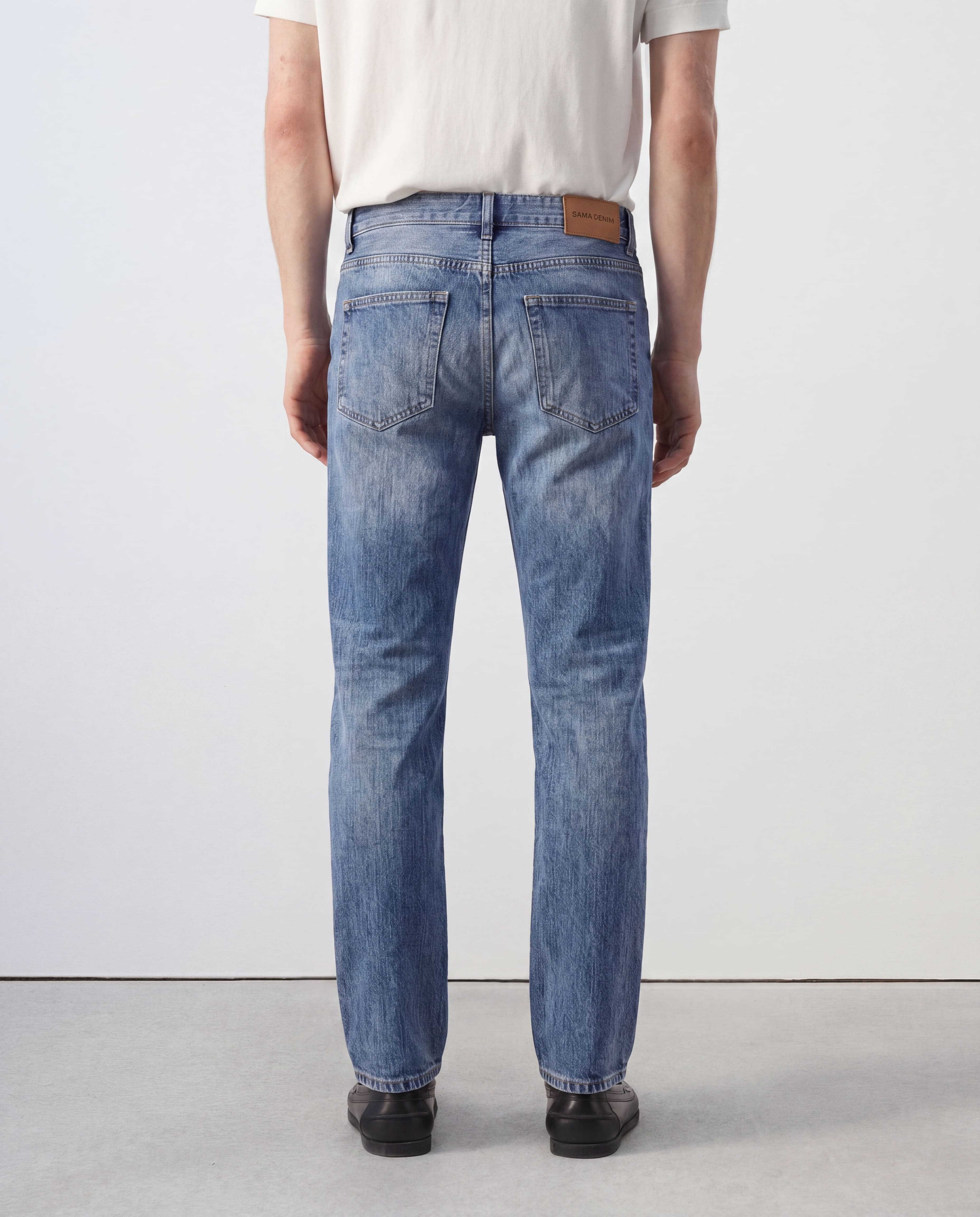 Back view of Sama Denim men's light wash slim fit jeans with minimalist styling