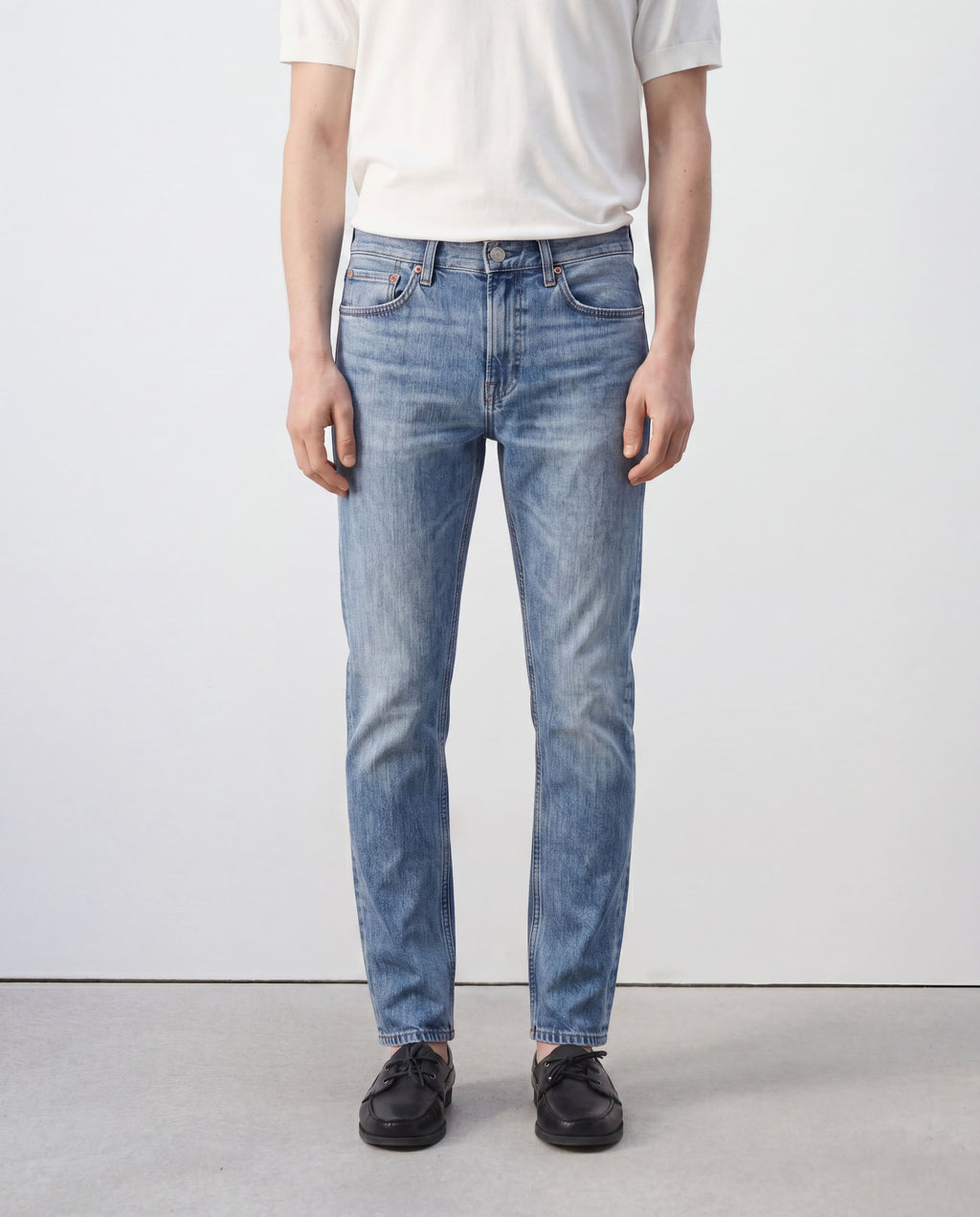 Model wearing Sama Denim men's light wash slim fit jeans front view with minimalist styling
