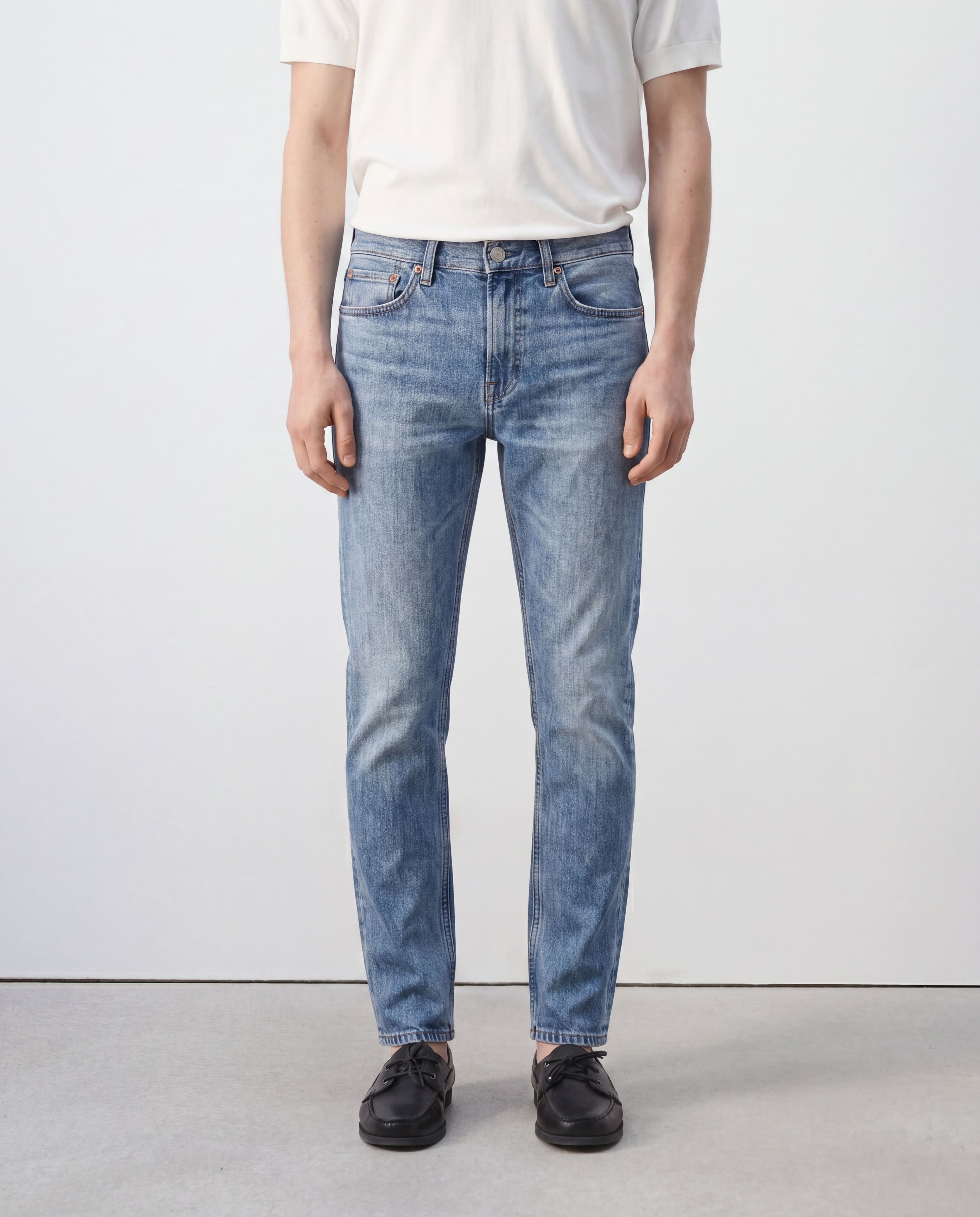 Model wearing Sama Denim men's light wash slim fit jeans front view with minimalist styling