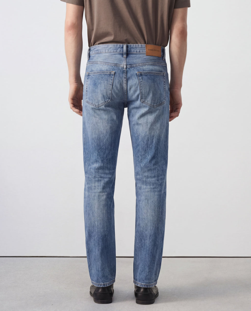 Back view of model wearing Sama Denim men's light wash straight fit jeans