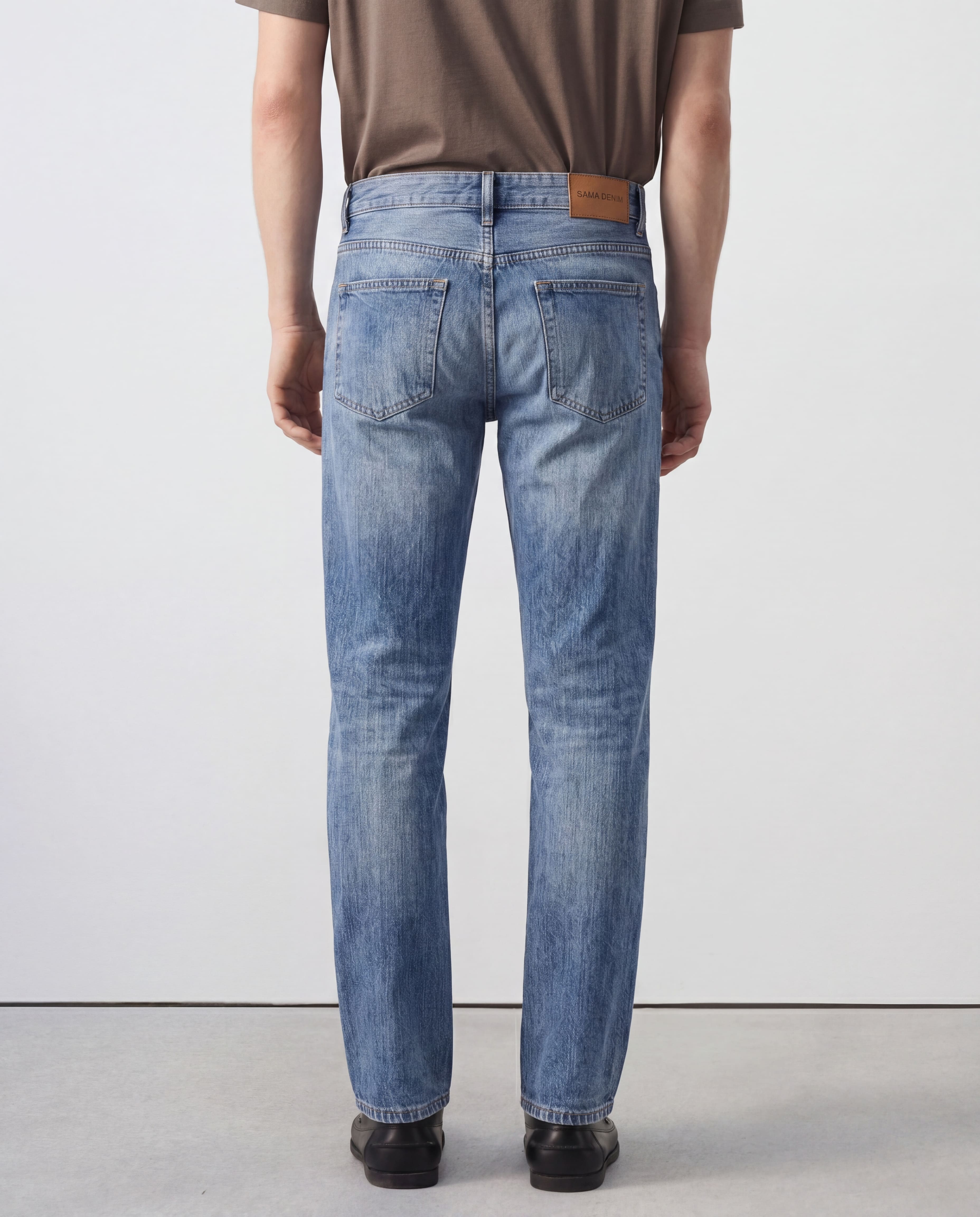 Back view of model wearing Sama Denim men's light wash straight fit jeans