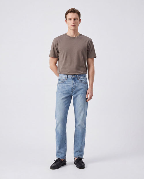Model wearing Sama Denim men's light wash straight fit jeans with minimalist styling